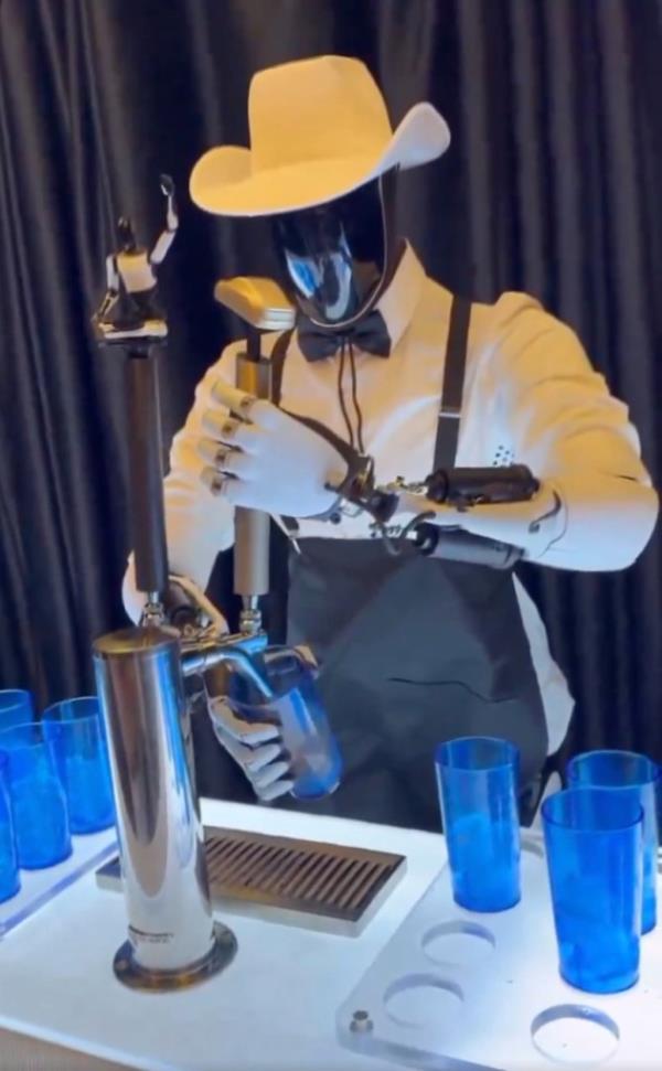 Optimus robot pouring drink into cup from a tap during Tesla event on Oct. 10, 2024.