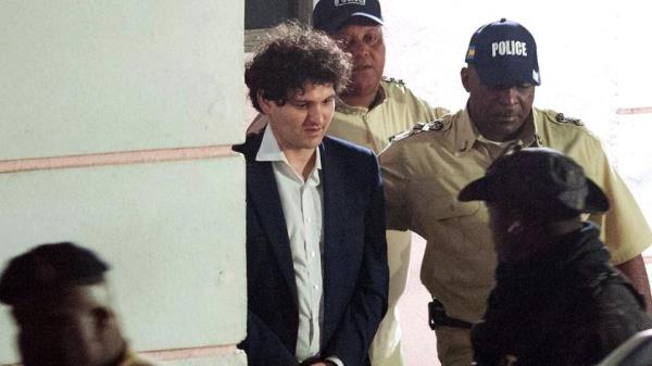 FTX founder Sam Bankman-Fried (2nd L) is led away handcuffed by officers of the Royal Bahamas Police Force in Nassau, Bahamas on 13 December 2022